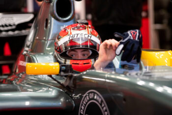 Racing driver in the cockpit of an F1 car wearing a race helmet