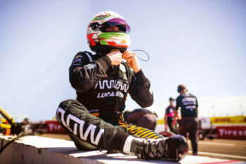 Clickable image of a racing driver in full racewear including suit, boots and race helmet