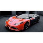 Red and black sports car with sleek design and aerodynamic features, parked on a dark surface.