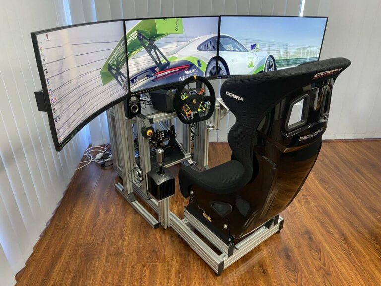 Grand Prix Racewear racing simulator with triple screens, racing seat, and steering wheel for immersive motorsport experience.
