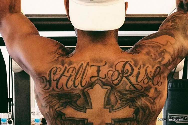 Lewis Hamilton's back, showing a large tattoo across his shoulder stating "Still I Rise"