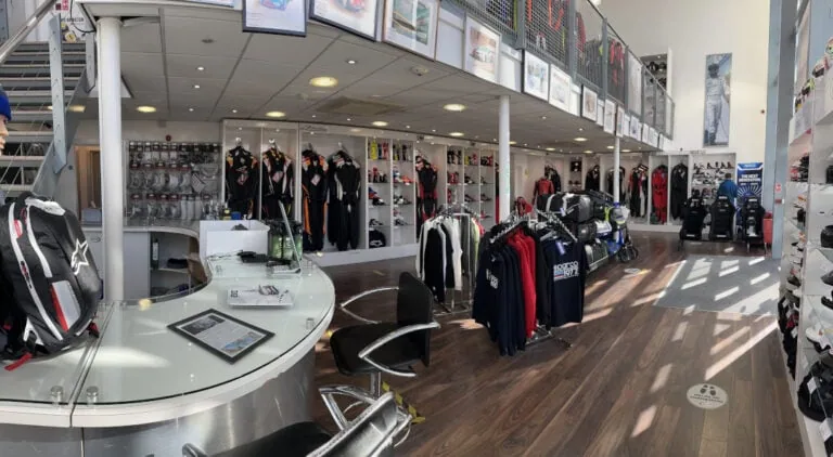 Interior of Grand Prix Racewear store showcasing racing suits, helmets, and accessories for motorsport enthusiasts.