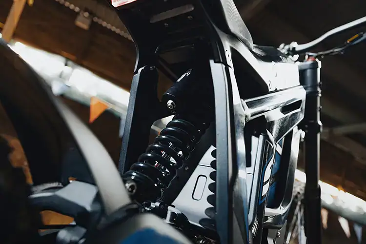 Close-up of a modern electric mountain bike frame with suspension system and sleek design.