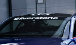 Close-up of a race car with Silverstone branding on the windshield, highlighting Grand Prix Racewear's sponsorship at a motorsport event.