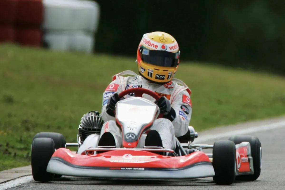 Lewis Hamilton's racing helmet in a go-kart during a race, showcasing vibrant colours and sponsor logos.