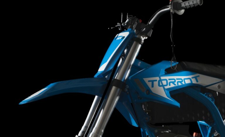 Close-up of a blue motocross bike with Grand Prix Racewear branding, highlighting safety gear and racing design.