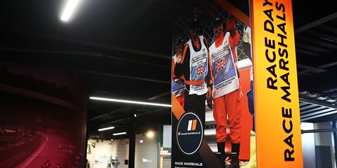 Grand Prix Racewear display featuring race marshals' uniforms at a motorsport event.