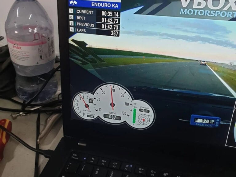 Enduro racing simulation on a computer screen showing lap times, speed, and track view at Grand Prix Racewear.