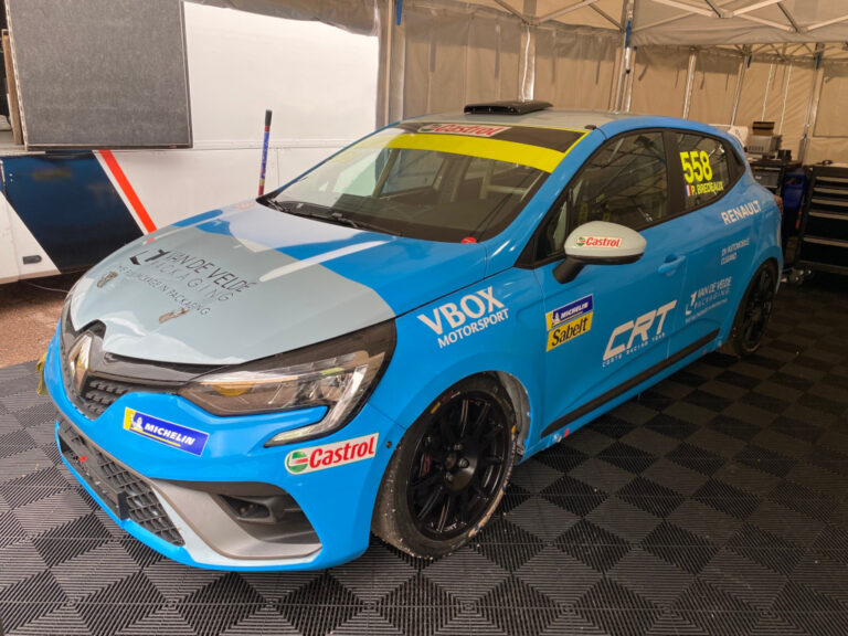 Renault race car with blue and black livery, racing number 558, under a tent at a motorsport event.