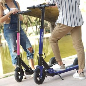 Two people with Sparco electric scooters outdoors near a river, showcasing the scooters' compact design and portability.
