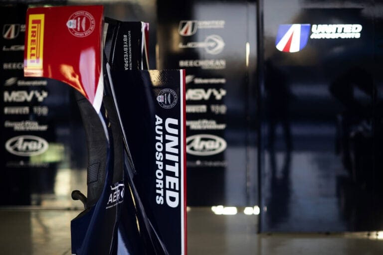 Grand Prix Racewear racing gear and accessories display at a motorsport event, featuring branded helmets and suits for professional racing.