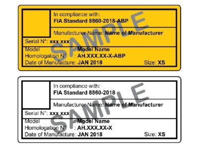 Close-up of FIA and Snell helmet certification labels showing compliance details and manufacturer information.