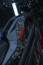 Close-up of a Talaria electric motorcycle with sleek black and red design, showcasing the branding and modern racing style.