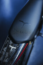 Close-up of a Talaria electric motorcycle seat with branding, showcasing sleek design and high-quality materials for racing and performance.