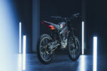 High-performance electric mountain bike showcased in a modern, dark setting with blue and white LED lighting for a sleek, professional look.