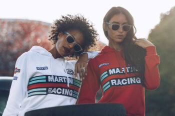 Two women wearing Grand Prix Racewear racing hoodies and sunglasses outdoors, showcasing stylish motorsport apparel.
