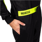 Close-up of a person wearing a black racing suit with a yellow Sparco belt, highlighting professional motorsport apparel.