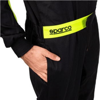 Close-up of a person wearing a black racing suit with a yellow Sparco belt, highlighting professional motorsport apparel.