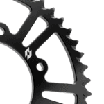 Close-up of a black bicycle chainring with sharp teeth, designed for high-performance cycling.