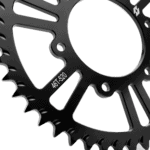 Close-up of a black bicycle sprocket with the size 46T-520 engraved on it, showcasing its teeth and design.