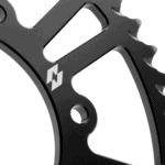 Close-up of a black racing gear component with a white logo, highlighting high-quality craftsmanship for motorsport safety gear.
