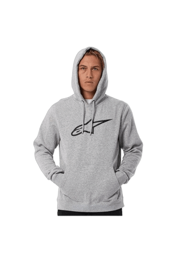 Young man wearing a grey Grand Prix Racewear hoodie with a black logo, standing with hands in pockets against a plain background.