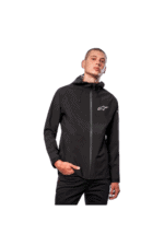 Young man wearing black Grand Prix Racewear jacket with Alpinestars logo, standing confidently against a plain background.