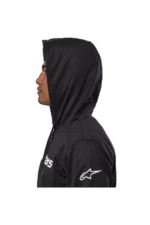 Side view of a person wearing a black Grand Prix Racewear hoodie with a hood up, featuring Alpinestars logo on the sleeve.