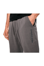 Close-up of a person wearing grey Spinestrars racing joggers with side pocket, suitable for motorsport enthusiasts.