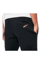 Close-up of a person wearing black Grand Prix Racewear trousers with Alpinestars logo, focusing on the back pocket area.