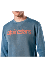 Close-up of a person wearing a blue Alpinestars racing sweatshirt with the logo prominently displayed.