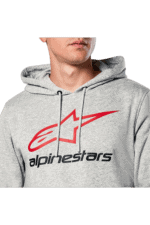 Close-up of a person wearing a grey Alpinestars hoodie with a red and black logo, suitable for motorsport enthusiasts.