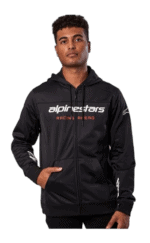 Young man wearing Grand Prix Racewear black racing hoodie with Alpinestars logo, standing confidently against a plain background.