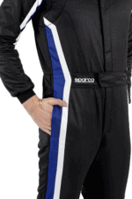 Close-up of a professional racing driver wearing a black racing suit with blue and white accents, featuring the Sparco logo, suitable for motorsport events.