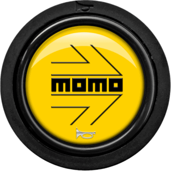 Close-up of a yellow and black Moto logo on a circular surface, representing motorcycle racing gear and accessories.