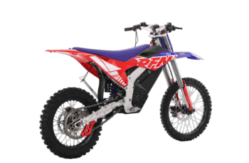 Red, blue, and white Grand Prix Racewear motocross bike with rugged tires and advanced suspension for off-road racing.