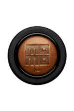 Close-up of a brown racing helmet with a black visor and a logo featuring a stylised 'M' and 'E' on the front.