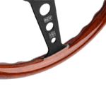 Close-up of a wooden steering wheel with black metal spokes featuring the Indy logo, used in race cars.