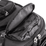 Close-up of a black racing backpack with multiple compartments and zippers, designed for Grand Prix racewear enthusiasts.
