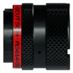 Close-up of a professional racing camera with a textured black body and red branding, used for capturing high-speed motorsport events.