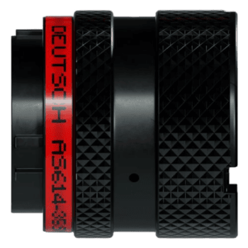 Close-up of a professional racing camera with a textured black body and red branding, used for capturing high-speed motorsport events.
