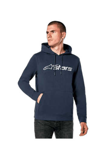 Man wearing a navy blue Grand Prix Racewear hoodie with Alpinestars logo, standing with hands in pockets, on a plain white background.