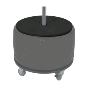 Rubber tire wheel with metal axle on a grey concrete base with caster wheels for mobility.