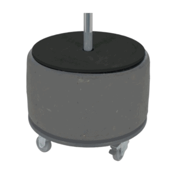 Rubber tire wheel with metal axle on a grey concrete base with caster wheels for mobility.