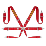 Red Sabelt racing harness with yellow logo, adjustable straps, and metal buckles for motorsport safety.