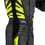Close-up of a professional racing suit from Grand Prix Racewear featuring black and yellow design with Sparco branding.