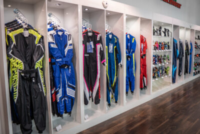 Display of Grand Prix racewear suits and accessories in a retail store, showcasing various racing suits in different colours and styles.