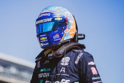 Formula 1 driver in Grand Prix Racewear helmet and racing suit, ready for the race, showcasing high-performance motorsport apparel.