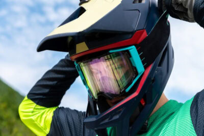 Close-up of a motocross rider wearing a full-face helmet with goggles, ready for a race, showcasing high-quality racing gear from Grand Prix Racewear.
