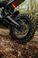 Close-up of a rugged off-road electric bike wheel with knobby tyre and disc brake, suitable for outdoor adventures.